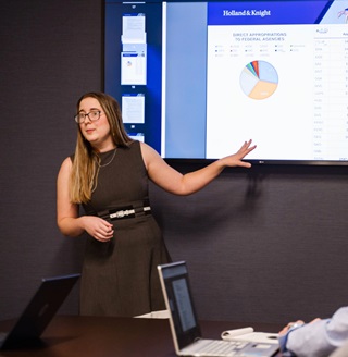 A woman presenting business data to a group.