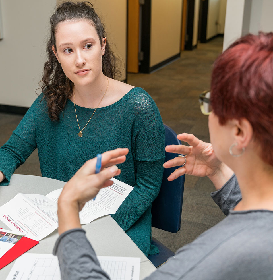 Student visiting with enrollment coordinator