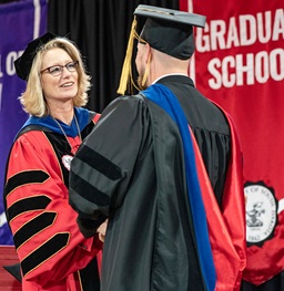 President Gestring shaking hands with a student at commencement