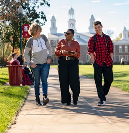 People walking down a sidewalk on campus