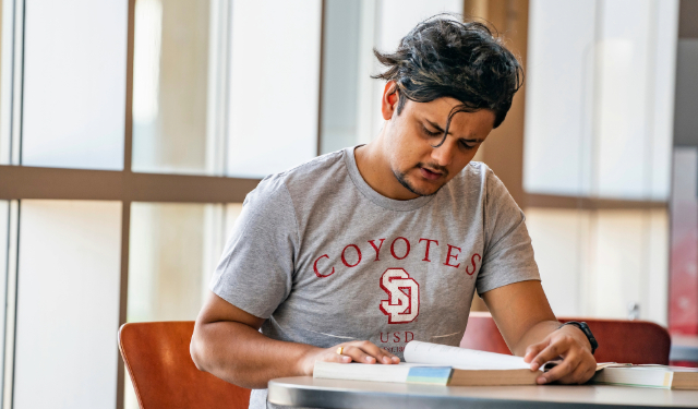 A student reading a textbook and studying.