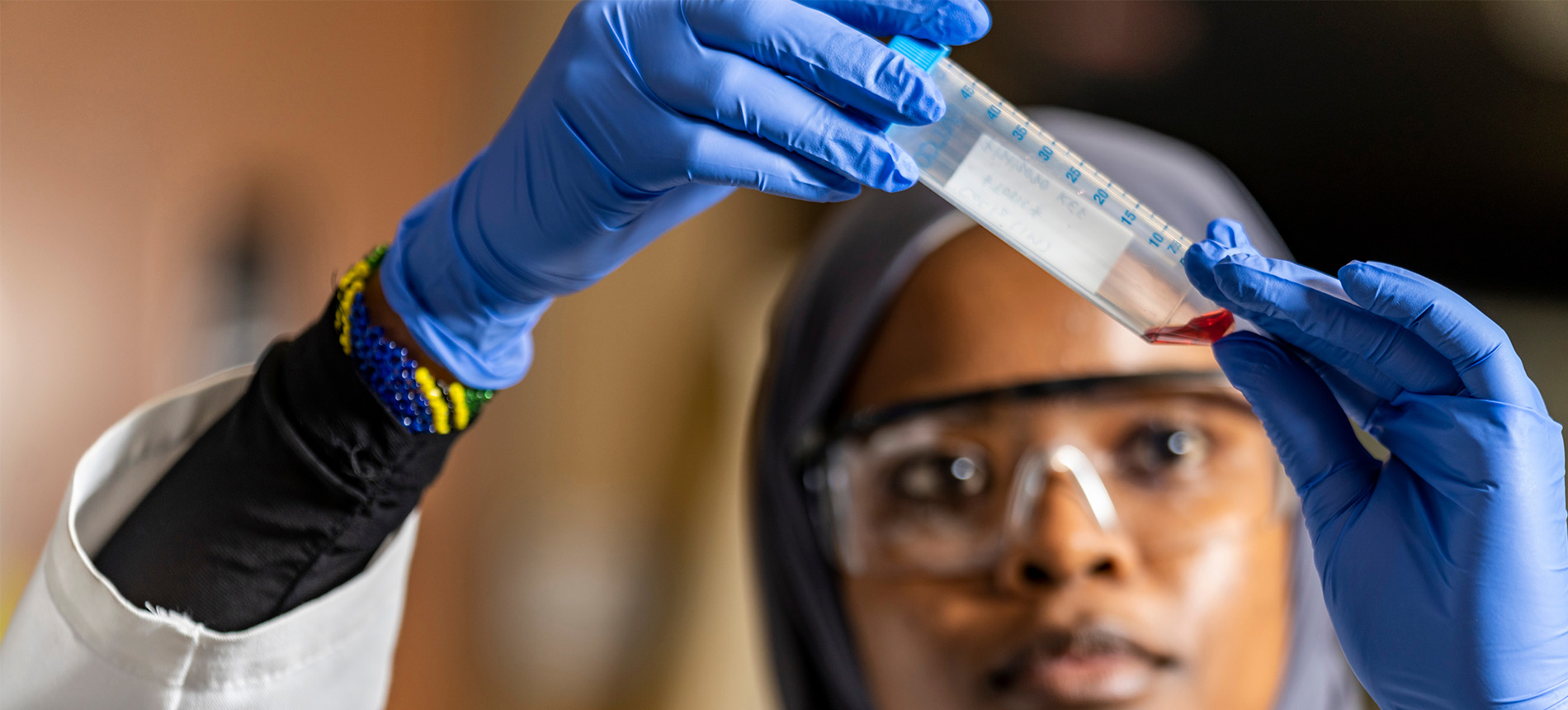 Student holding up a test tube and examining its contents