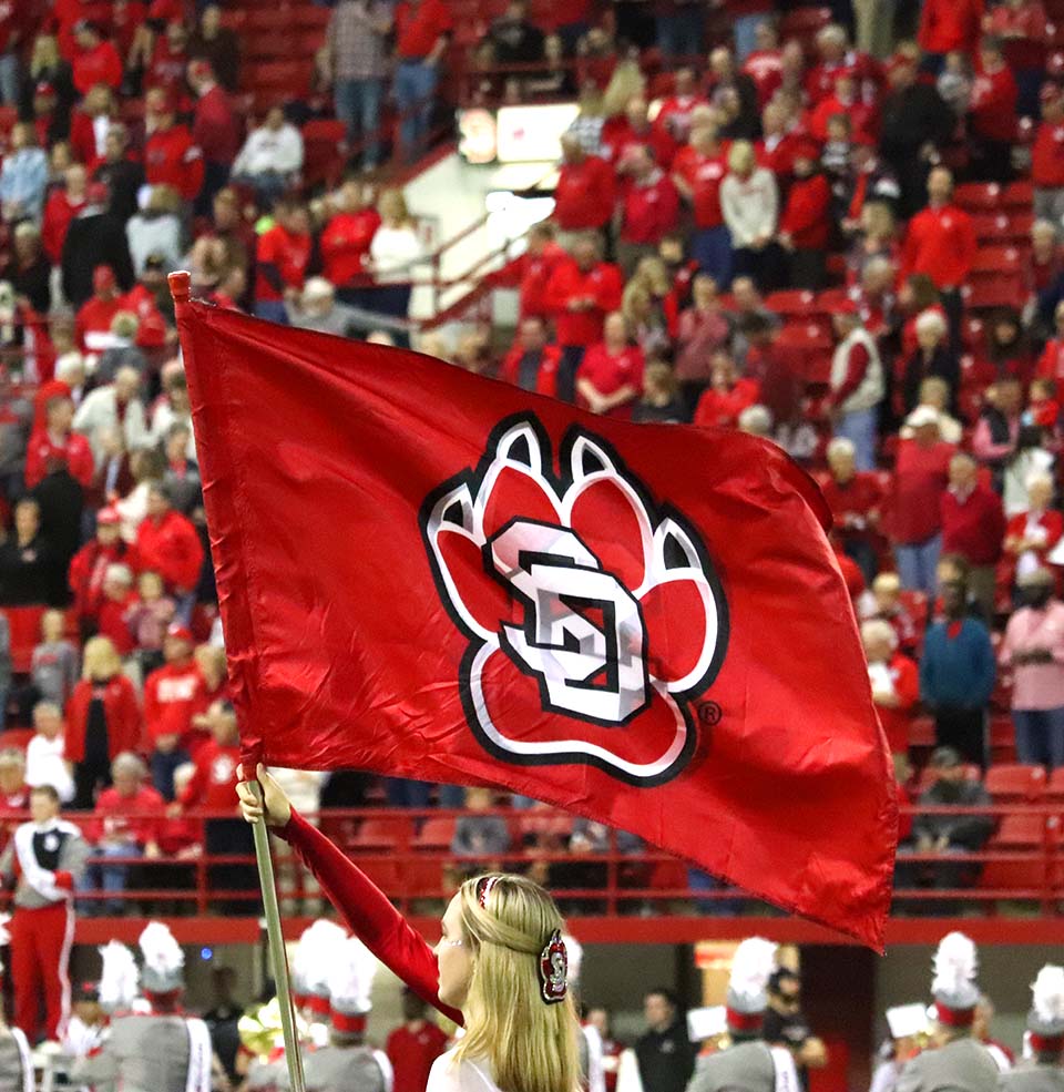 A Cheer member holding a flag in the DakotaDome.