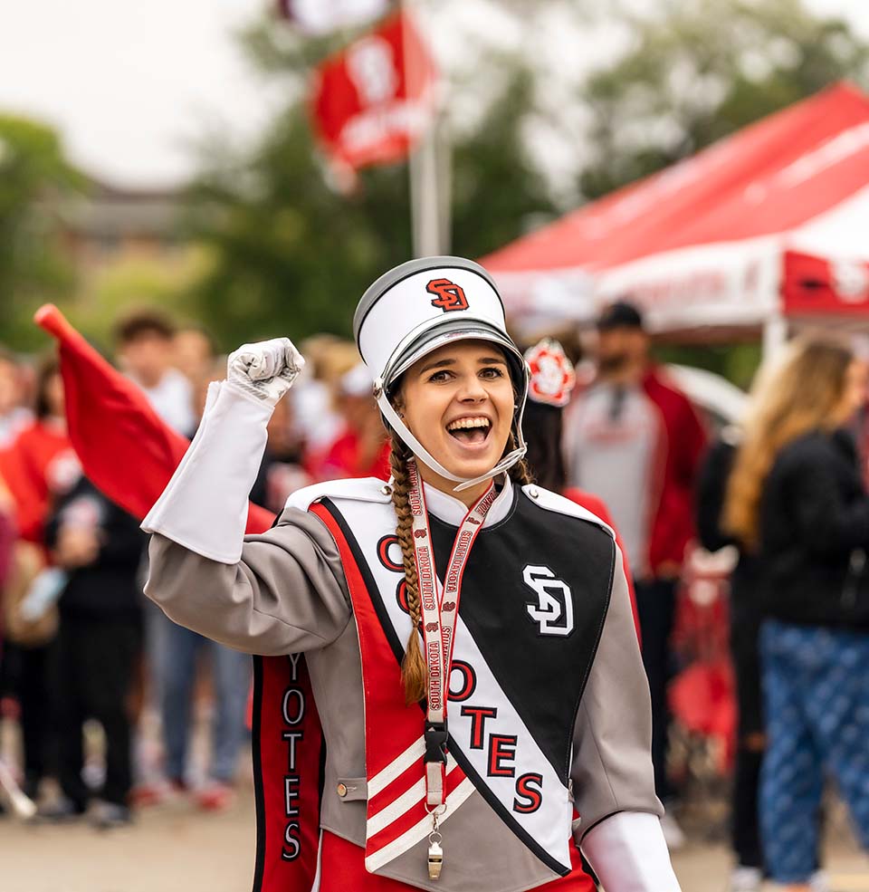 A Sound of USD bad member cheering at the Dakota Days parade.