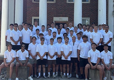 Delta Tau Delta group photo in front of fraternity house. 