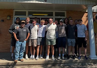 Pi Kappa Alpha group photo taken in front of fraternity house.