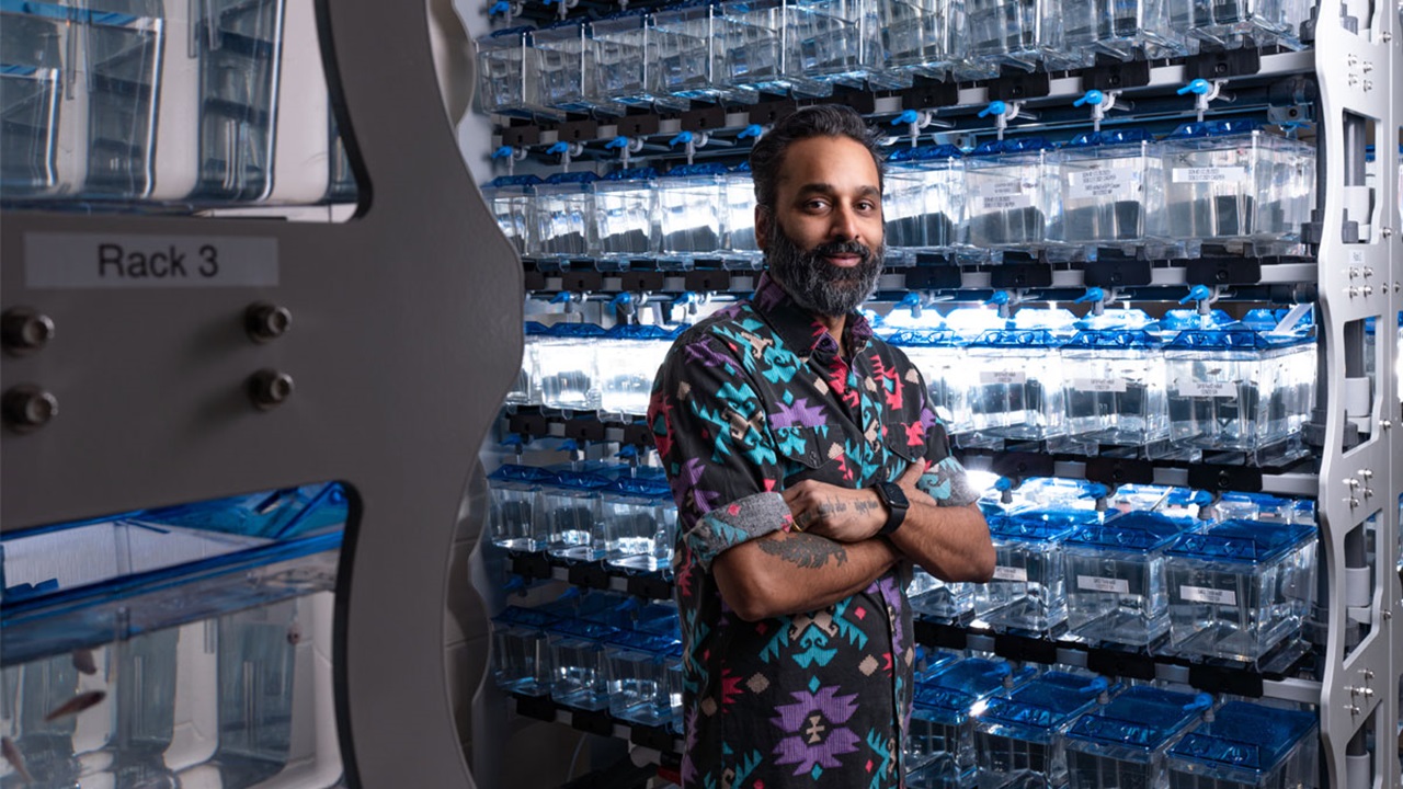 Yohaan Fernandes standing in front of racks in lab
