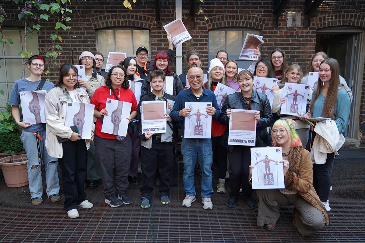 USD art students stand with an NYC artist, holding copies of his work.