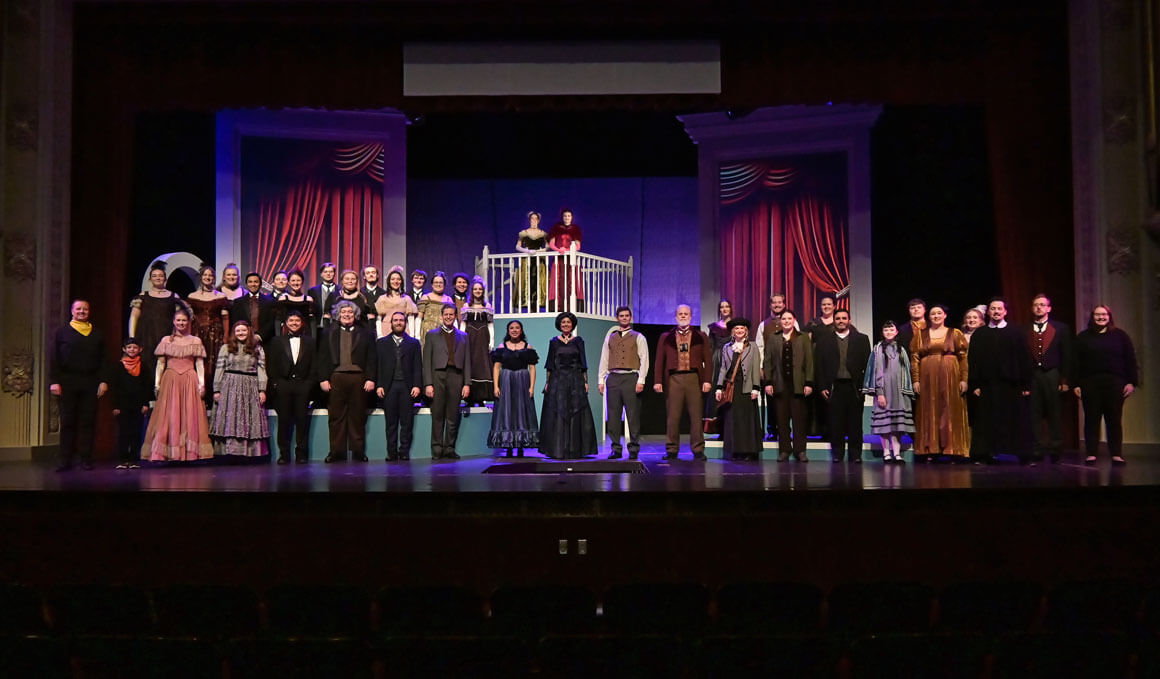 A group of USD students stand on stage, in costume, from the show "Notes on Viardot".
