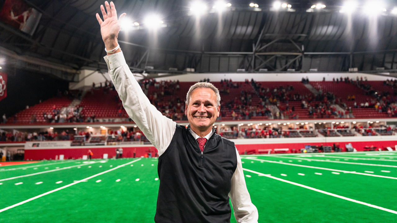 Bob Nielson, former USD head football coach, stands in the Dakota Dome and waves to the crowd.