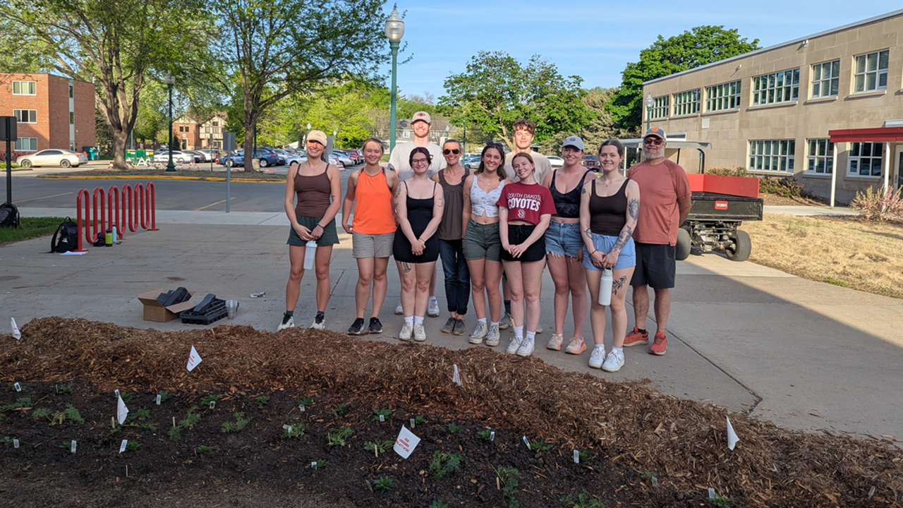 USD students and faculty pose for a photo during the sustainability planting project.