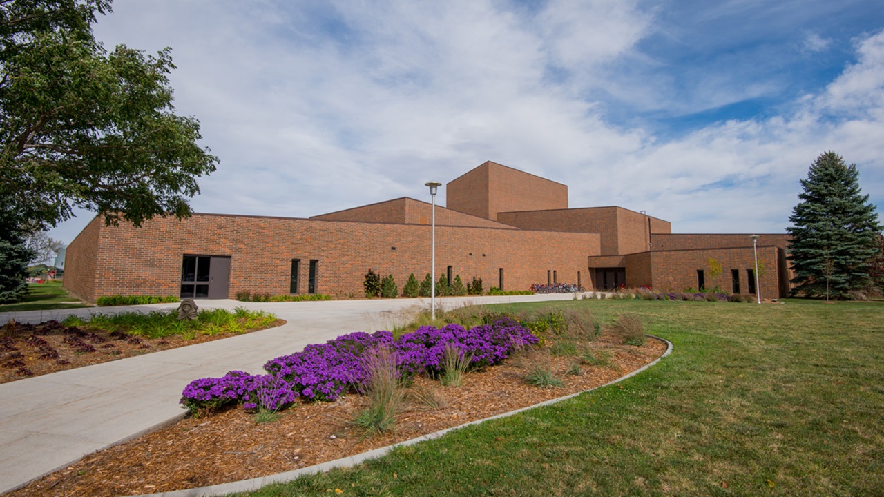 The Center for Fine Arts exterior sits on a sunny USD campus with beautiful purple flowers.