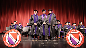 Jakob Lund, '25, poses for a photo with faculty on the Knudson School of Law graduation stage for his hooding ceremony.
