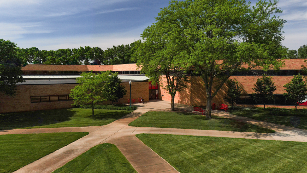 The Knudson School of Law building sits against a beautiful blue sky on a sunny day.