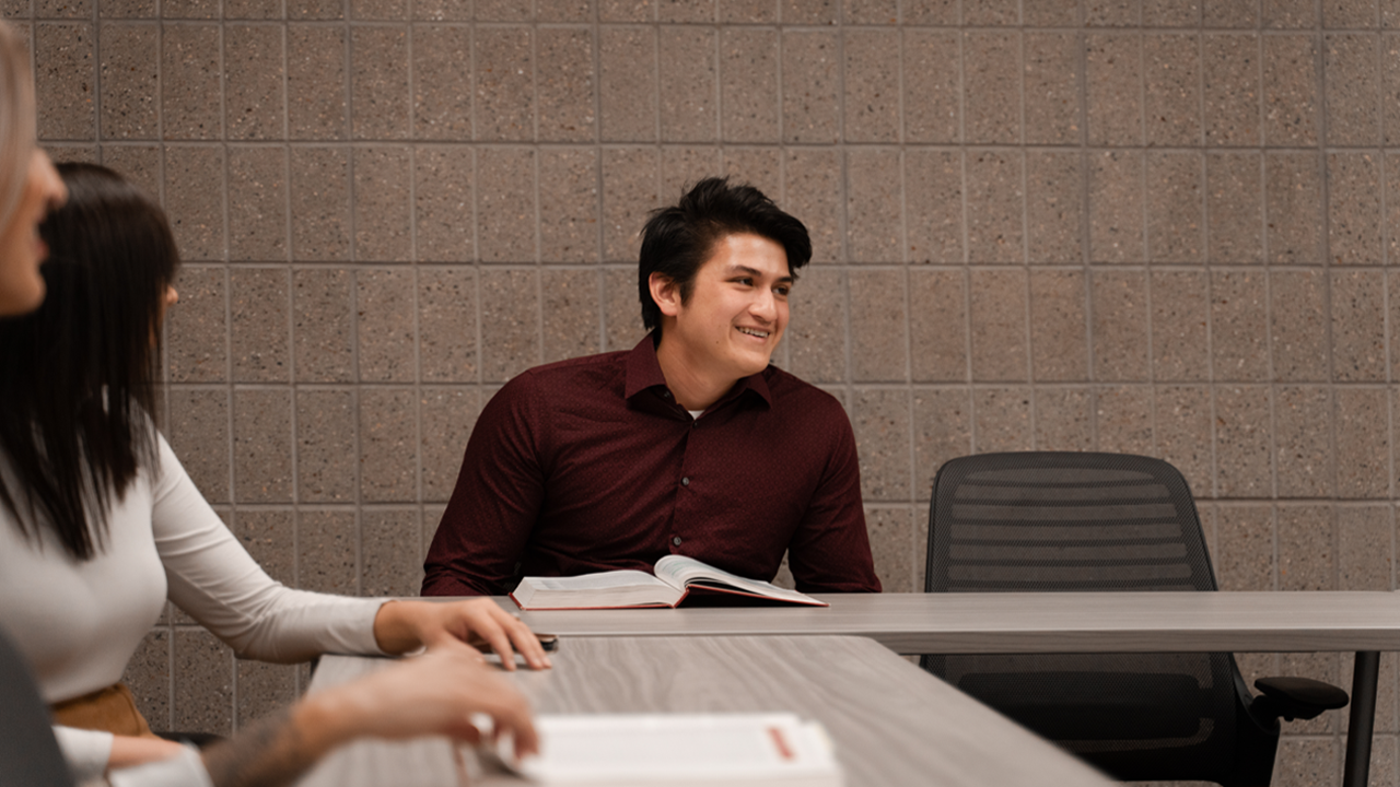 A Knudson School of Law student smiles at his classmates.