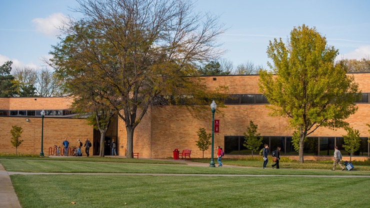 Front exterior of the Knudson School of Law, with students walking in front of it.