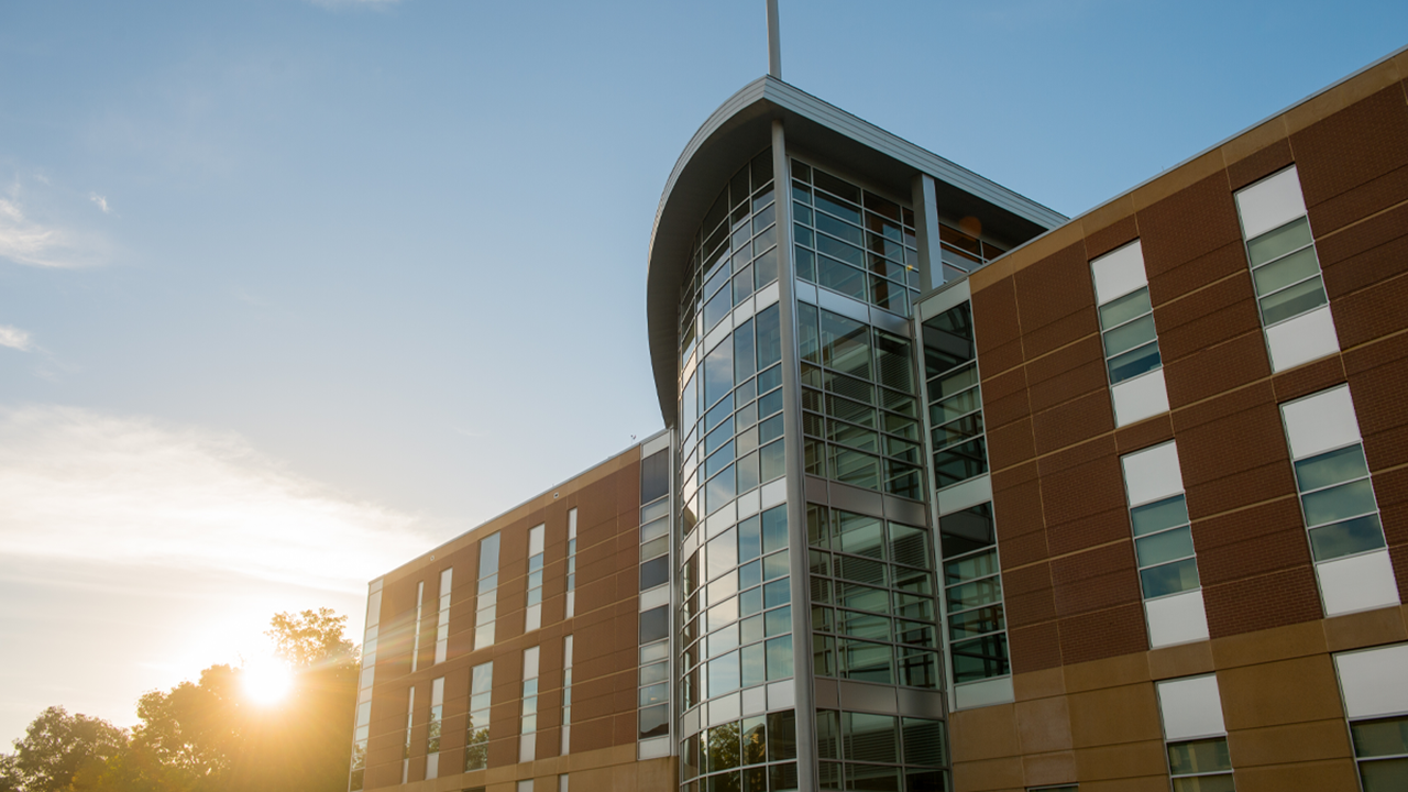 A sunrise sits over the The Lee Medicine Building on the USD campus.