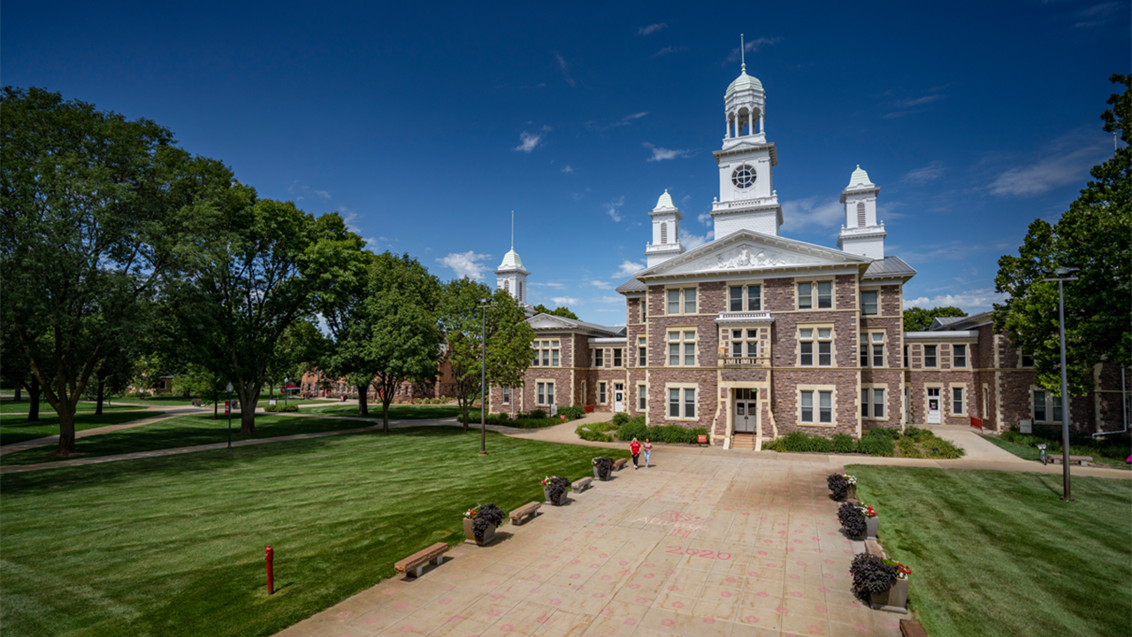 USD's Old Main sits on a sunny campus with clear, blue skies in the background.
