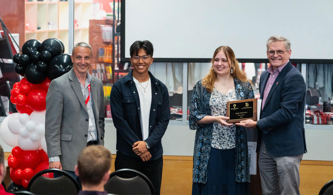 Ariestotle Raj Maharjan and Margaret Kathol accept their award as first-place winners in the USD Hackathon. 