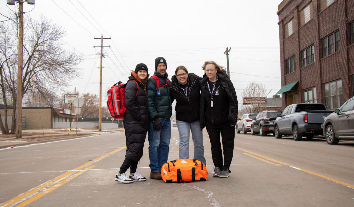 A group photo of the MWSM team standing on a road in downtown Sioux Falls.