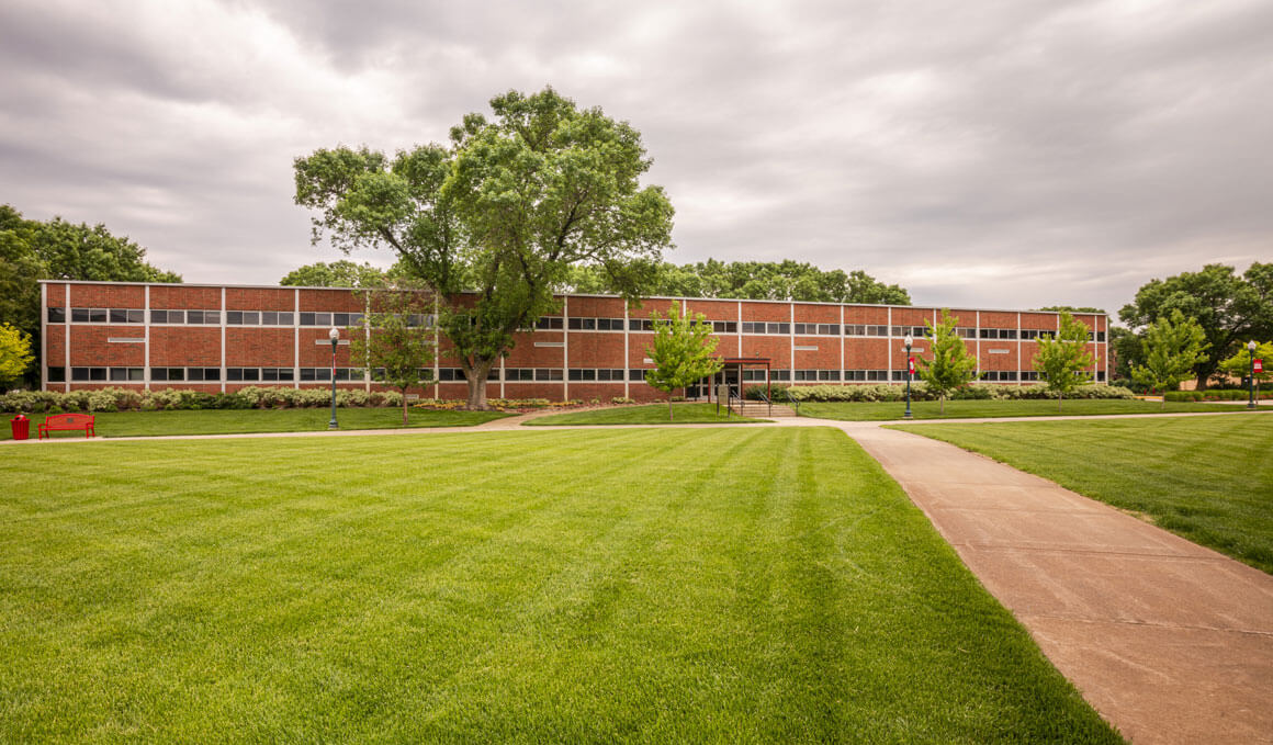 The Delzell Education Center sits on the USD campus, with an overcast sky in the background.