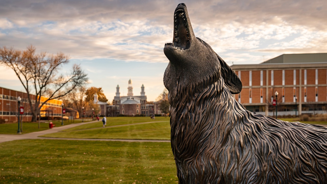 A close up shot of Legacy in the fall with Old Main, Delzell, and the library in the background.