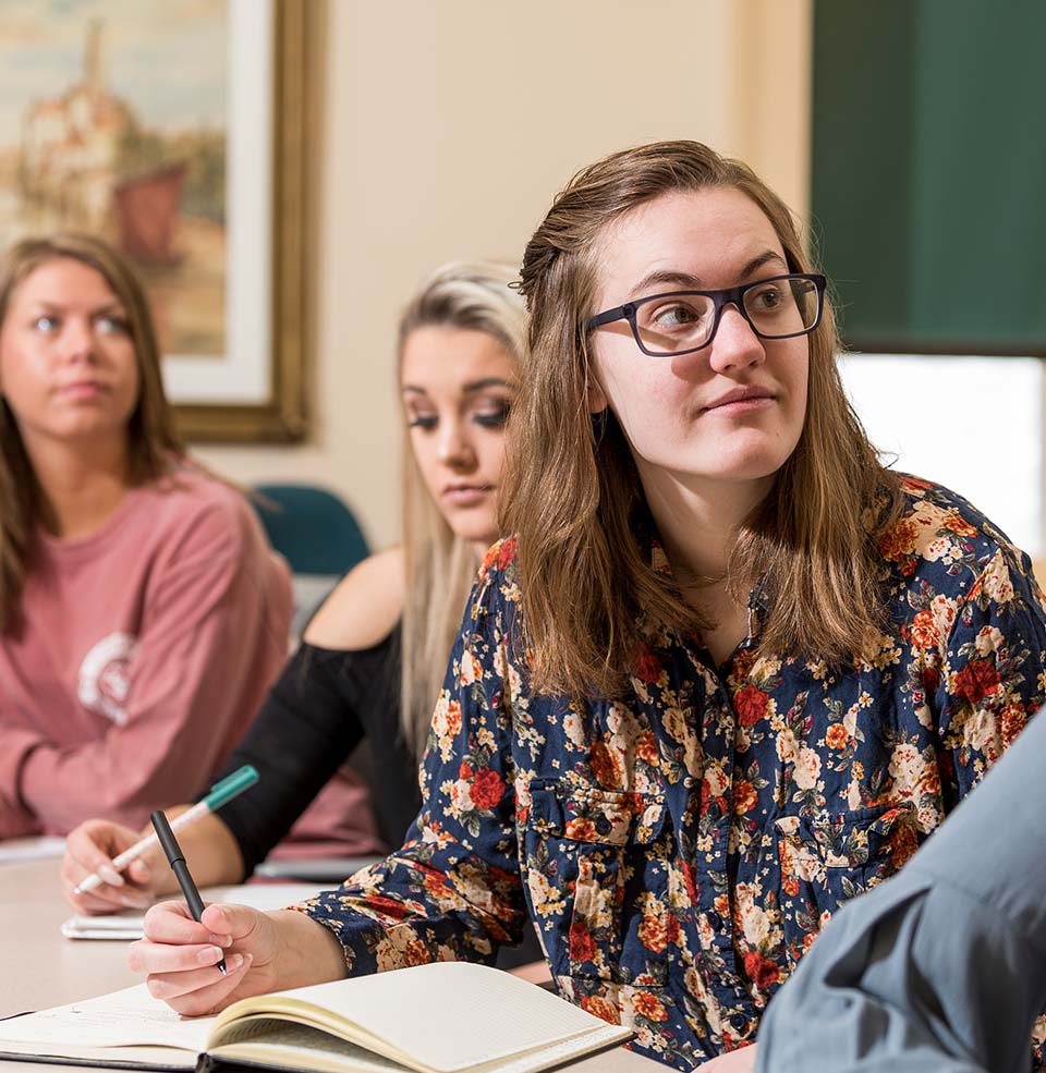 Students listening to a lecture and writing.