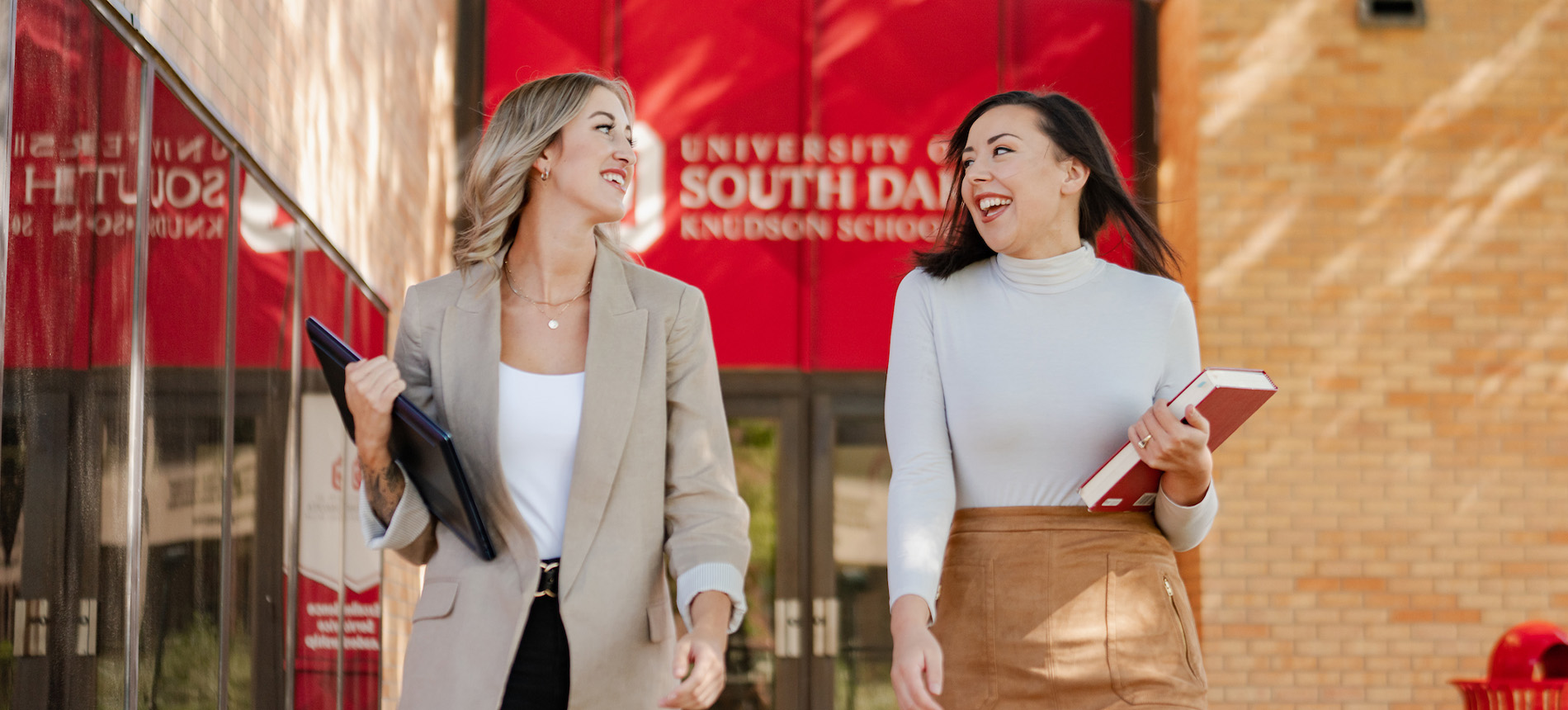 Two students walking out of the Knudson School of law.