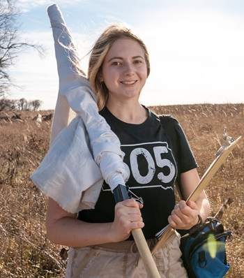 Success story Holly Black in a field doing research.