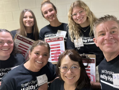 Graduate students and faculty from USD are pictured with friends while attending the South Dakota Special Olympics Summer Games.