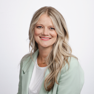 Julianne Severson, third year law student, poses for her headshot while wearing a mint green cardigan and white shirt.