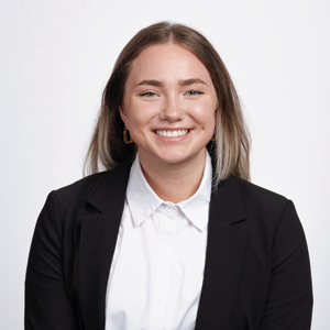 Tia Vlasman, third year law student, poses for her headshot while wearing a black cardigan and white shirt.