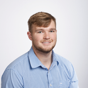 Jacob Howard, third year law student, poses for his headshot wearing a blue and white checkered and collared shirt.