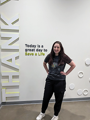 Madeline Vagts, USD Sanford School of Medicine student, stands in front of a "Thank You" sign.