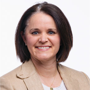 Denise Arrick posing for headshot in front of white wall