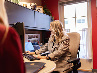 Ahslin Schoenfelder works at her computer with a student.