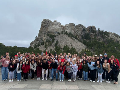 President's Senior Leadership Institute students stand in front of Mount Rushmore.