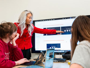 Young Ae Kim, Ph.D., points to a screen while teaching students. 