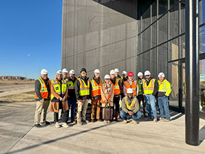 USD President Sheila K. Gestring, USD Discovery District Interim President and CEO James W. Abbott and guests from the university pose for a group photo outside the USD Discovery District.