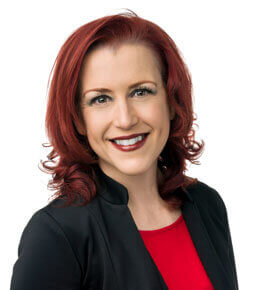 Mandie Weinandt poses for her professional photo. She is wearing a black button up shirt with a red shirt underneath.
