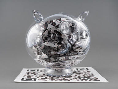 A glass piece of artwork that contorts around black and white materials, depicting letters in red. The piece sits atop a QR code that is barely visible underneath the glass.