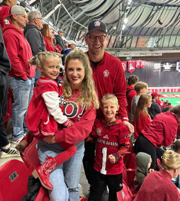 Kyle and Ashlin Schoenfelder stand in the stands, with their kids, inside the DakotaDome.